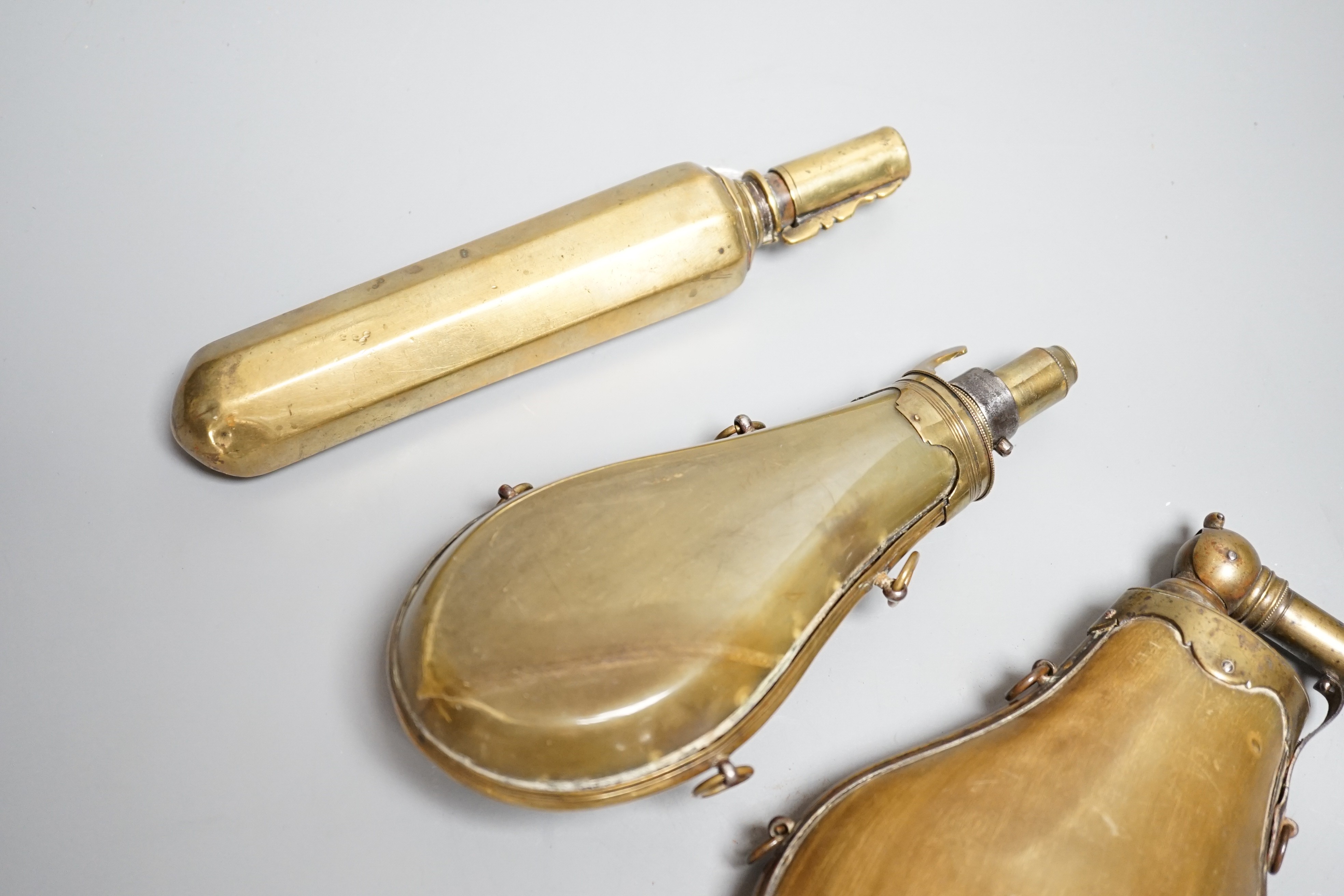 Two French lant horn powder flasks with brass mounts c.1800, one with graduated folding charger, and another unusual octagonal brass powder flask. Maximum 20cms